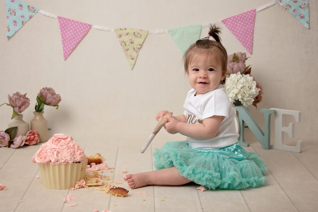 Classic cake smash by Samphire Photography Sussex flowers bunting bespoke
