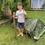 boy in front of camo tent