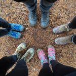 five pairs of feet wearing walking boots