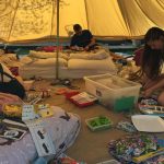 people doing craft activities in a tent