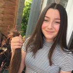 smiling teenage girl holding bunch of hair