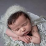 Little boy in green choosing a newborn photographer in Horsham