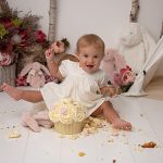 happy girl with cuddly bunnies cake smash