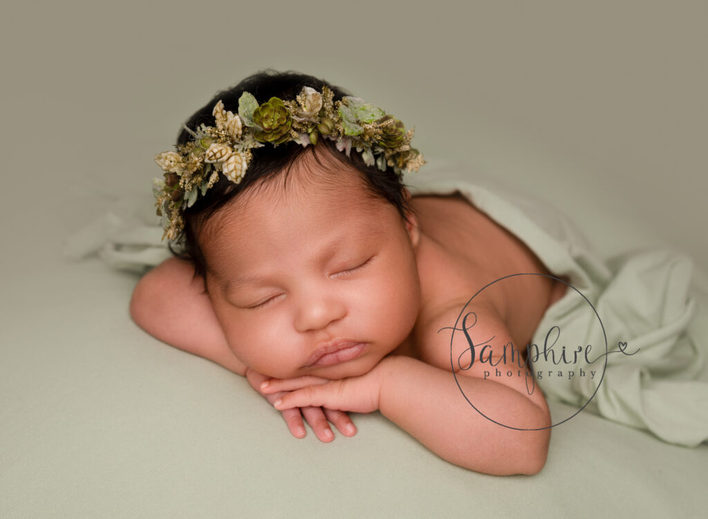 sleeping 1 month newborn baby wearing pretty green floral headband