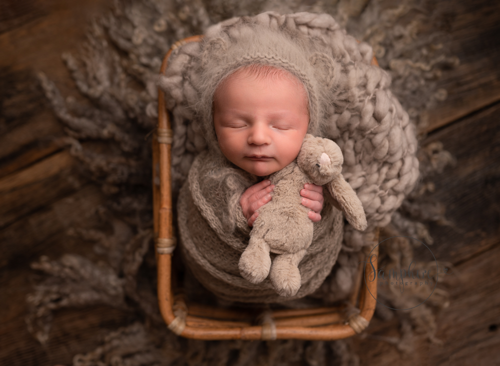 newborn asleep cuddling toy bunny