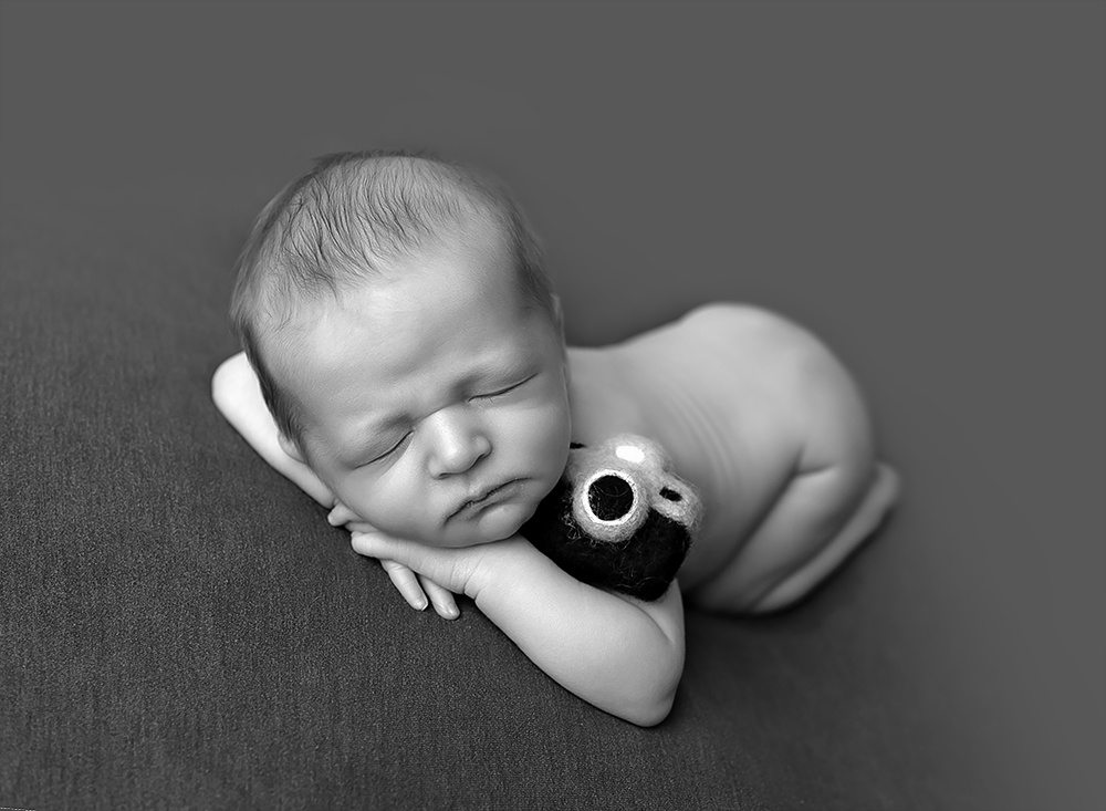 Sleeping baby boy in black and white and a camera toy by Samphire Photography