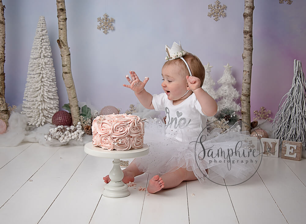 young girl enjoying her winter wonderland styled cake