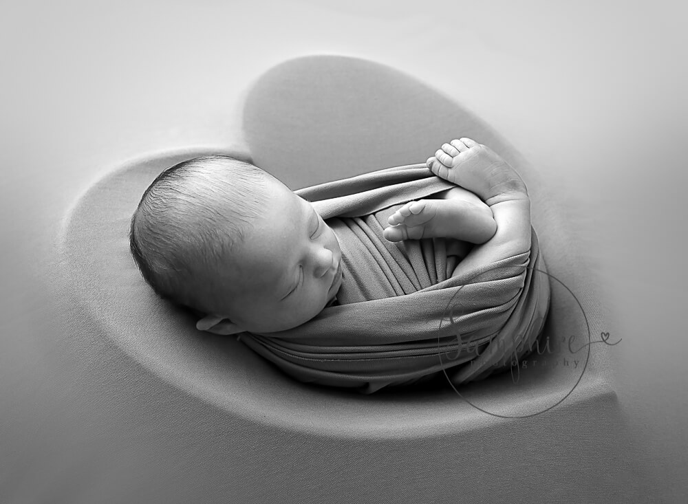 black and white image of boy in heart bowl