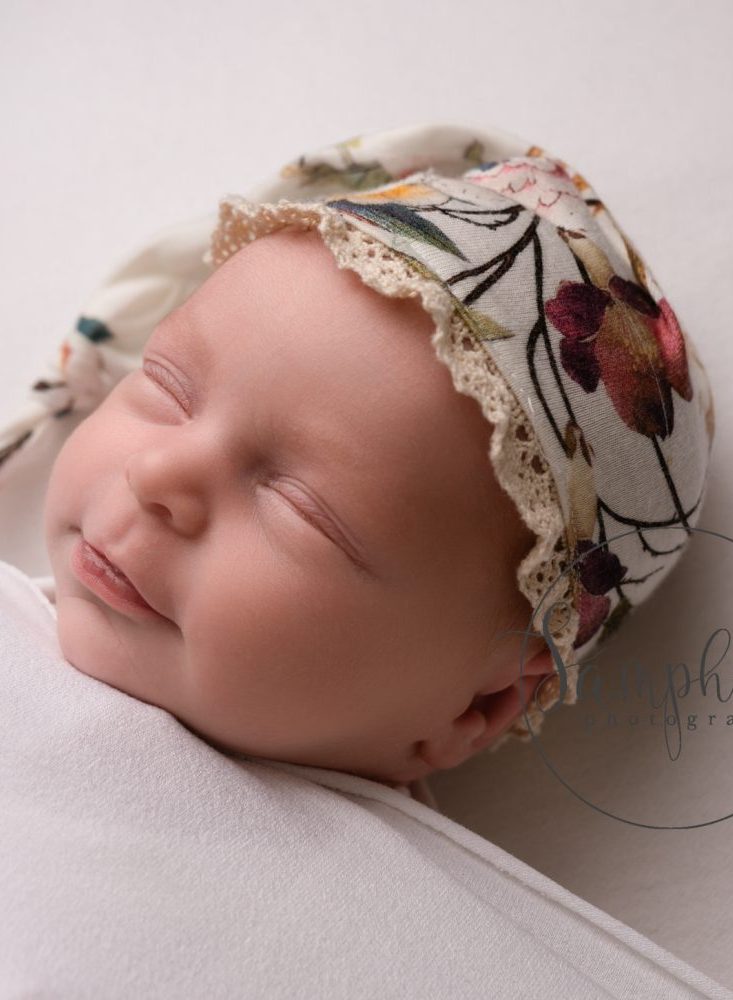 girl in floral hat at her newborn photoshoot near slinfold