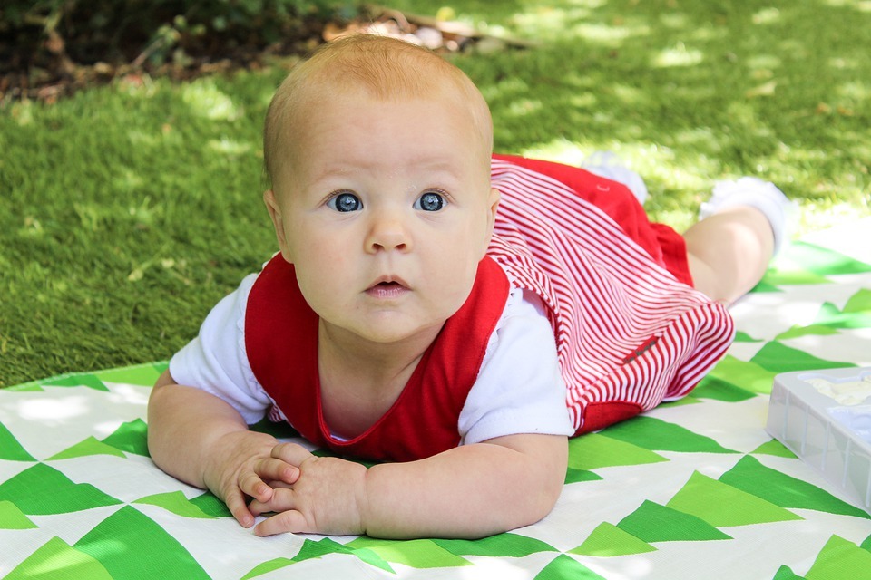 older baby girl keeping cool outdoors in summer shade