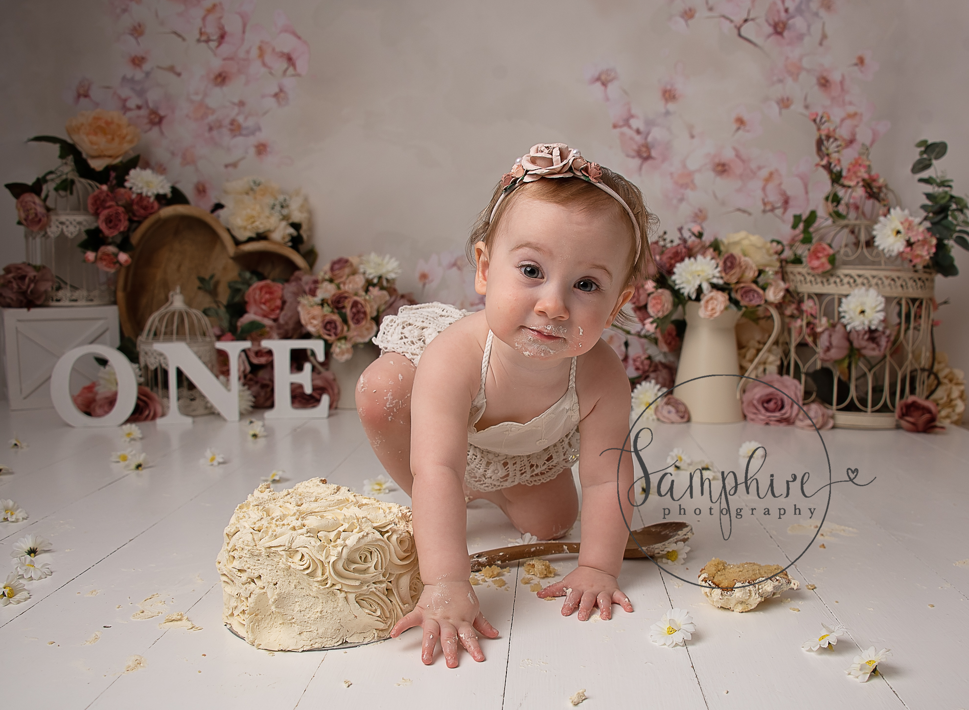 little girl crawling on the floor during her cake smash photoshoot billingshurst