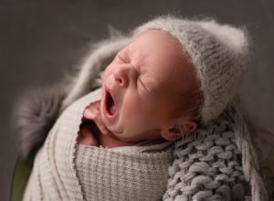 Newborn baby yawning during studio photoshoot