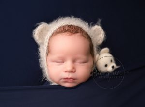 Baby asleep wearing knitted teddy ears hat